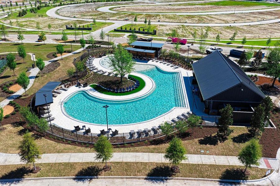 The property features a large, irregularly shaped swimming pool with integrated steps, surrounded by a paved deck with lounge chairs