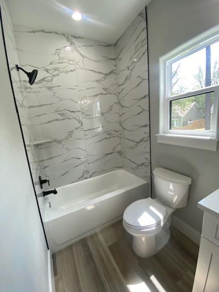 A well-appointed bath with striking tiled shower and a window for natural light. A well-appointed bath with striking tiled shower and a window for natural light.