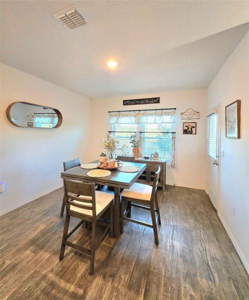 Dining area featuring wood-finish flooring, a window with horizontal blinds, and recessed lighting