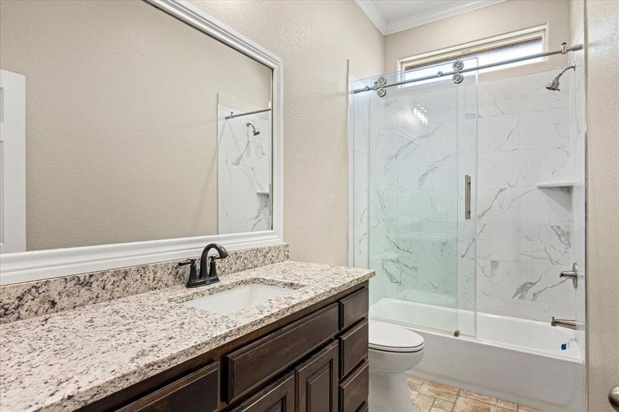 Full bathroom with vanity, a textured wall, shower / bath combination with glass door, and ornamental molding  4403 N. Port Ridglea Ct. Granbury,TX 76049