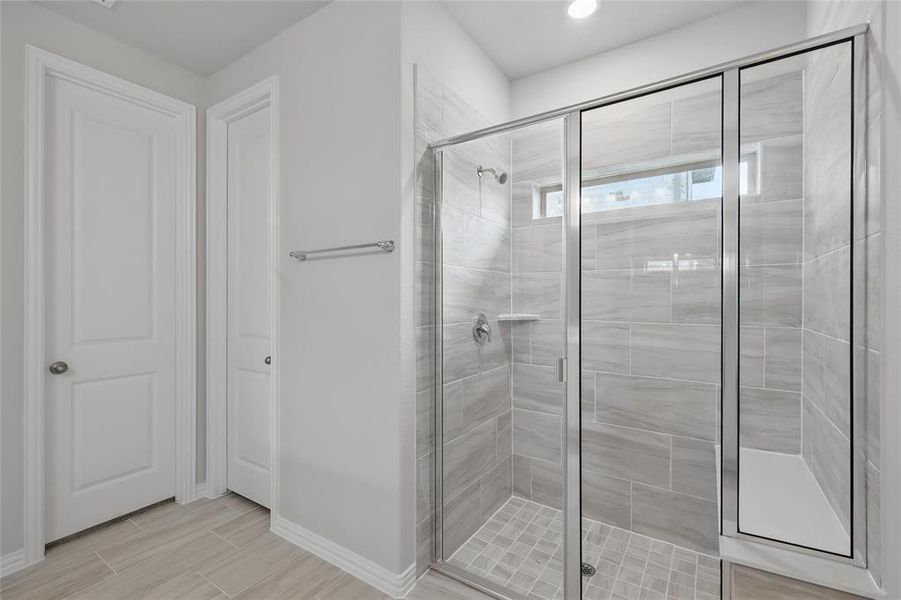 Bathroom featuring a stall shower and wood finish floors