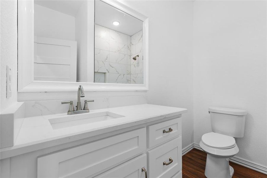 Bathroom with vanity, dark wood-style floors, and a marble finish shower Bathroom with vanity, dark wood-style floors, and a marble finish shower