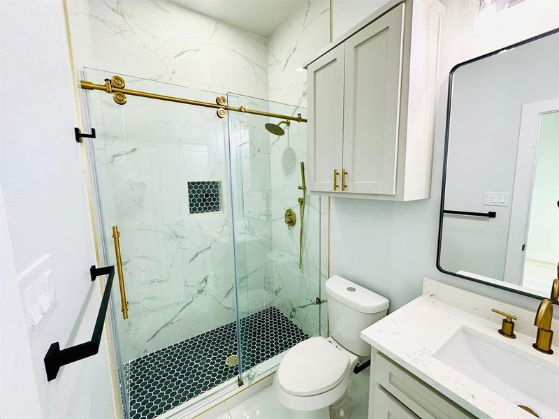 Bathroom featuring vanity, an enclosed shower, and toilet