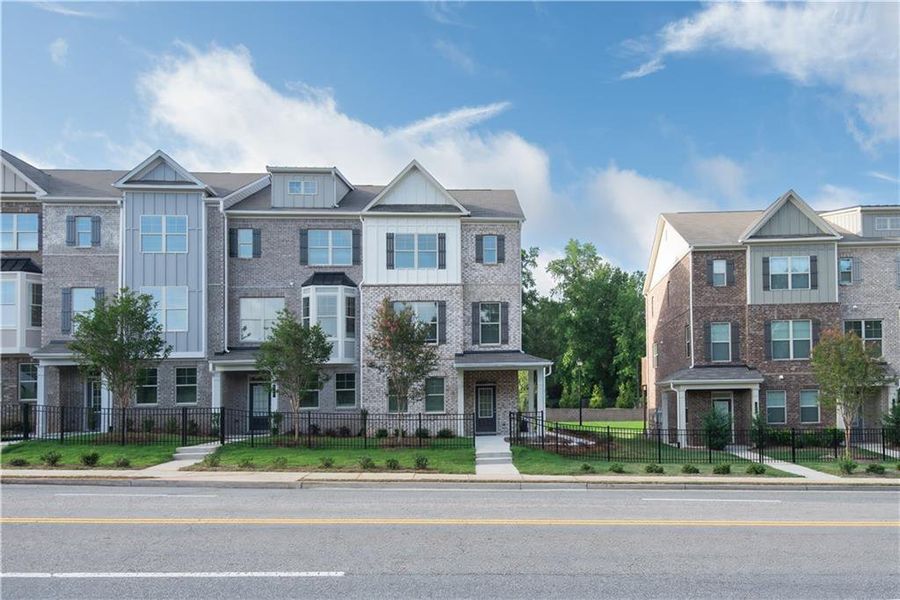 Front exterior of a new home in Towns at Enclave, Lawrenceville, GA, highlighting curb appeal (Image 2). Front exterior of a new home in Towns at Enclave, Lawrenceville, GA, highlighting curb appeal (Image 2).