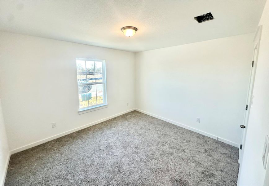Empty room featuring carpet and baseboards