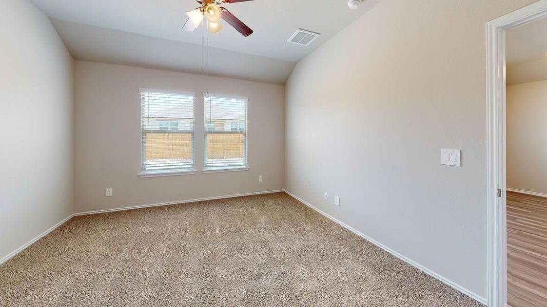 Spare room with ceiling fan, light carpet, and vaulted ceiling
