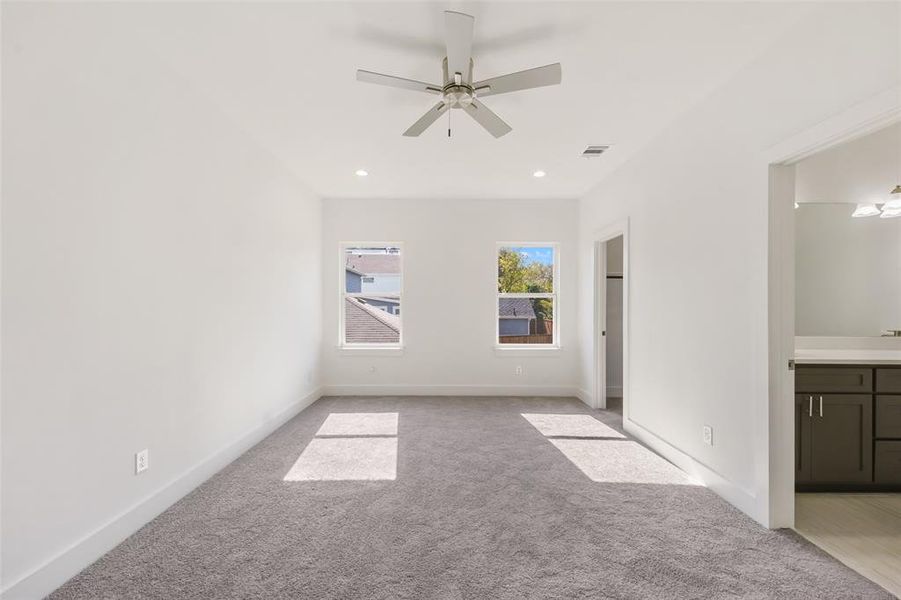 Unfurnished bedroom with light carpet, a ceiling fan, ensuite bath, and recessed lighting