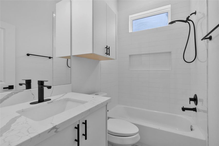 Spa-inspired bath featuring crisp white tilework, sleek matte-black fixtures and refined modern detailing. Spa-inspired bath featuring crisp white tilework, sleek matte-black fixtures and refined modern detailing.