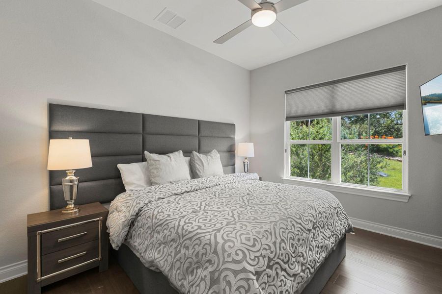Well-lit sleeping quarters with rich hardwood flooring and outdoor views.