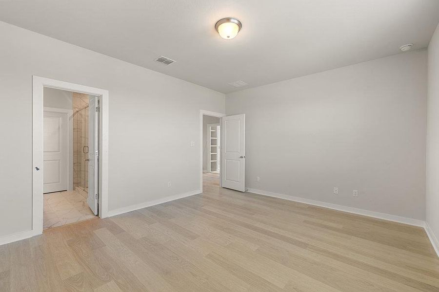 Unfurnished bedroom featuring light wood finished floors and ensuite bath