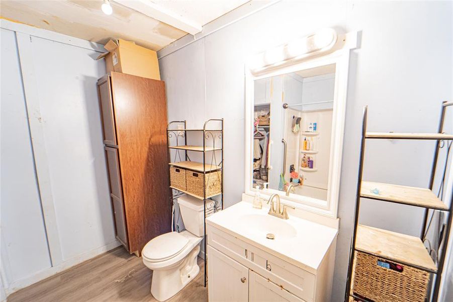 Half bathroom featuring vanity and light wood-type flooring Half bathroom featuring vanity and light wood-type flooring