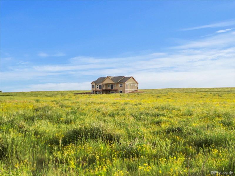 2. Aerial view of the home under construction, showcasing the home’s placement on a wide, open parcel.