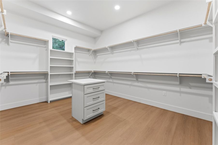 Walk in closet with light wood-style floors