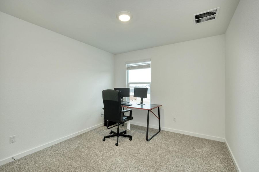 Carpeted office space featuring baseboards and visible vents