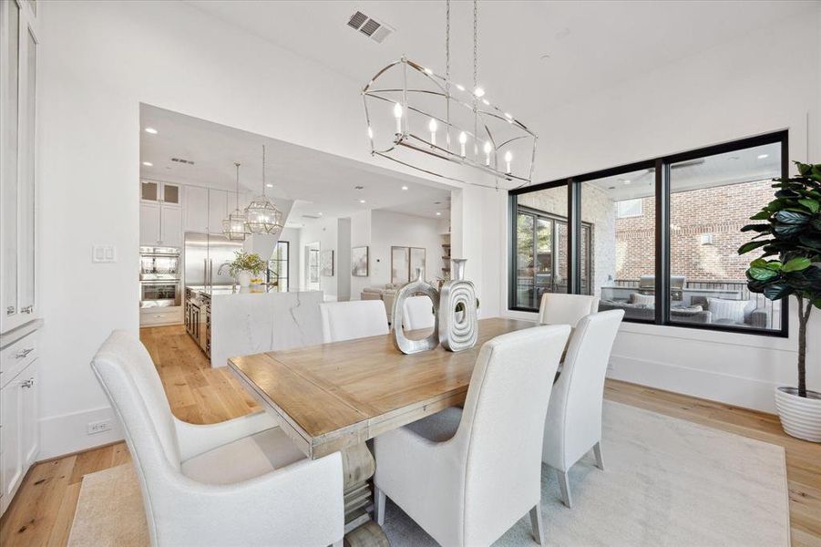 Experience the epitome of open-concept elegance in this stunning dining room where spaces exude an airy ambiance that seamlessly blends with the surrounding environment. The custom-built cabinets, tastefully integrated into the room's architecture, not only add a touch of sophistication but also provide practical storage solutions.