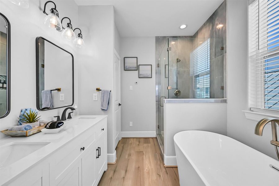 This first primary bedroom ensuite includes double vanities and a beautiful soaking tub with separate shower to make this bathroom ideal for busy mornings and hosting overnight guests with ease.