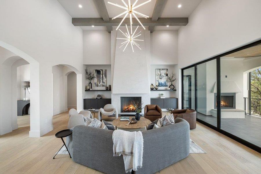 Vaulted living room with exposed wood beams and a contemporary chandelier