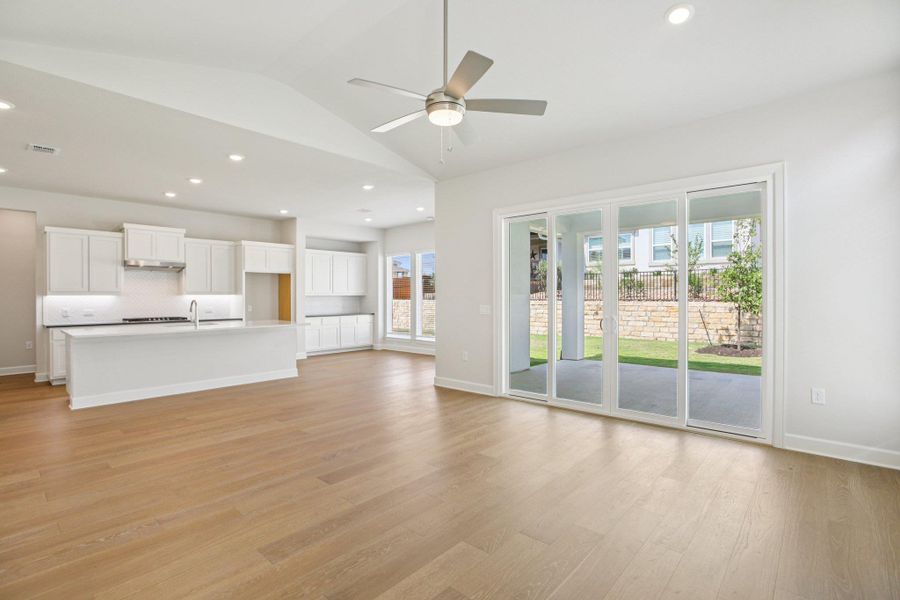 Unfurnished living room with recessed lighting, plenty of natural light, light wood-type flooring, vaulted ceiling, and ceiling fan