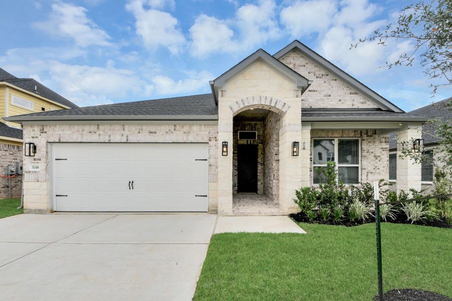 Meticulously maintained yard and lush landscape, paired with a premium elevation featuring captivating brick accents. Modern coach lights add a touch of contemporary elegance to the exterior.