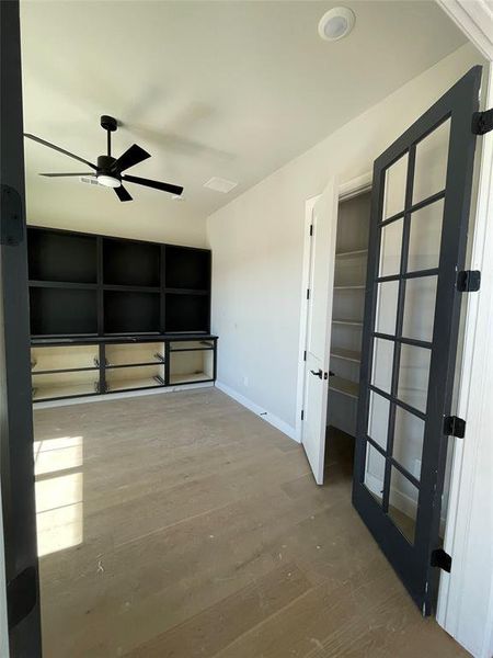 Empty room with wood finished floors and a ceiling fan