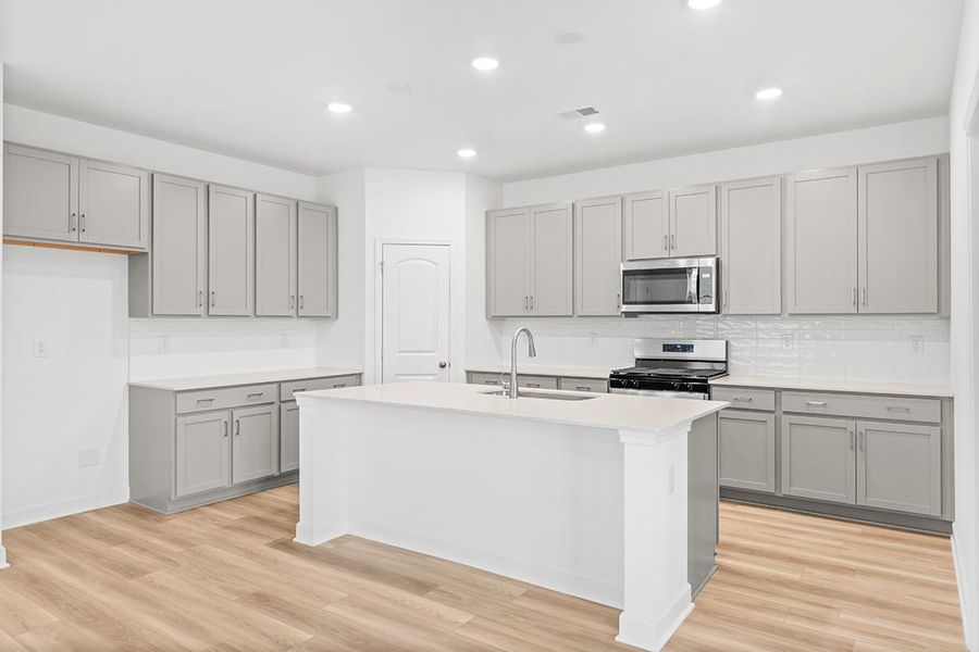A kitchen with white cabinets.