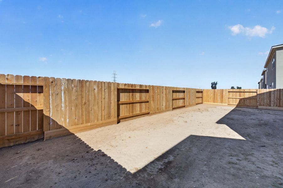A wooden fence in a dirt lot. A wooden fence in a dirt lot.