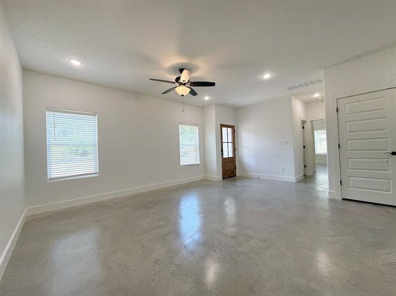 Spare room featuring a ceiling fan, recessed lighting, and finished concrete floors Spare room featuring a ceiling fan, recessed lighting, and finished concrete floors