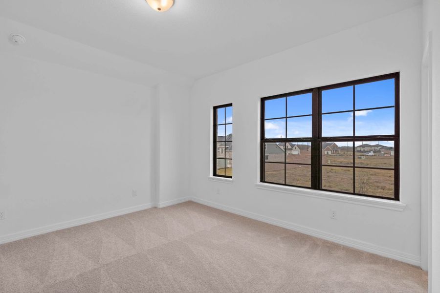 A secondary bedroom designed with timeless proportions and interesting windows. A secondary bedroom designed with timeless proportions and interesting windows.
