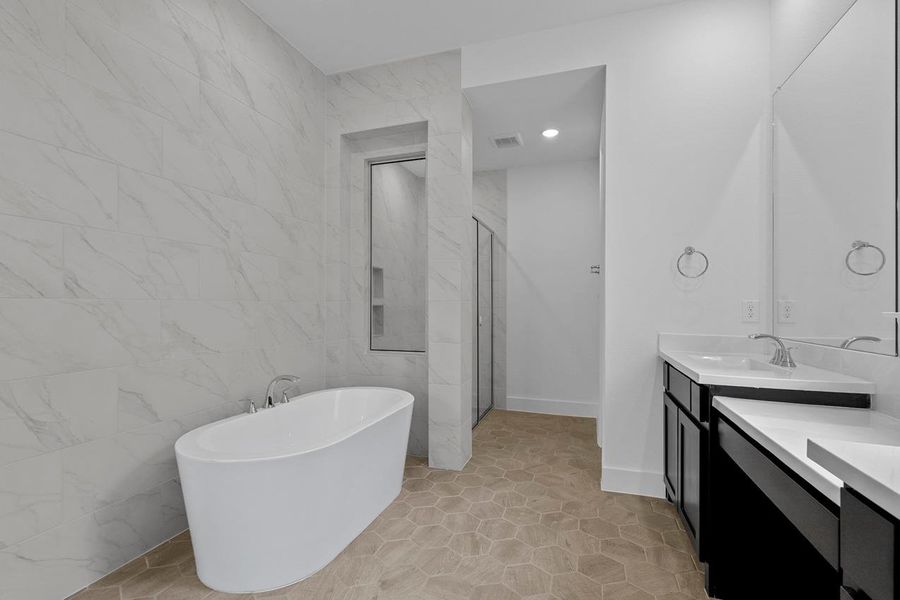 Full bath featuring a shower stall, a freestanding bath, vanity, and visible vents Full bath featuring a shower stall, a freestanding bath, vanity, and visible vents