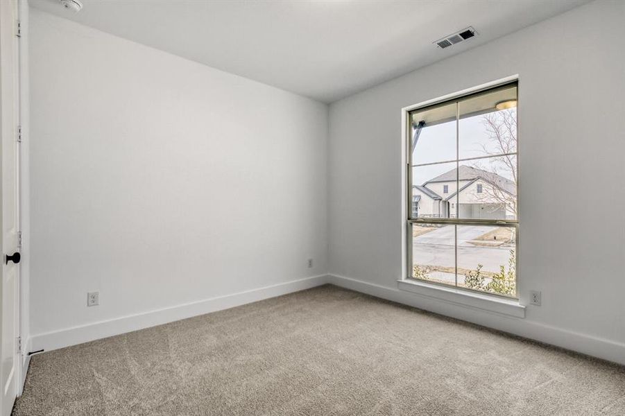 Empty room with light colored carpet and baseboards