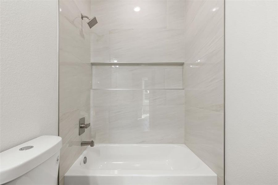 Bathroom featuring toilet and tiled shower / bath