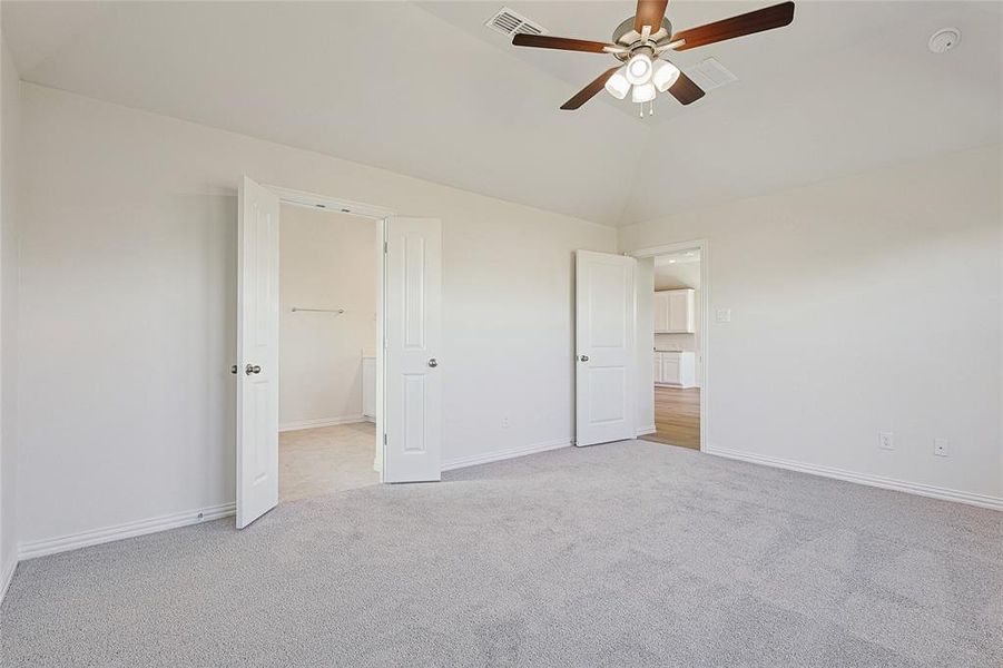 Unfurnished bedroom with lofted ceiling, light colored carpet, and ceiling fan