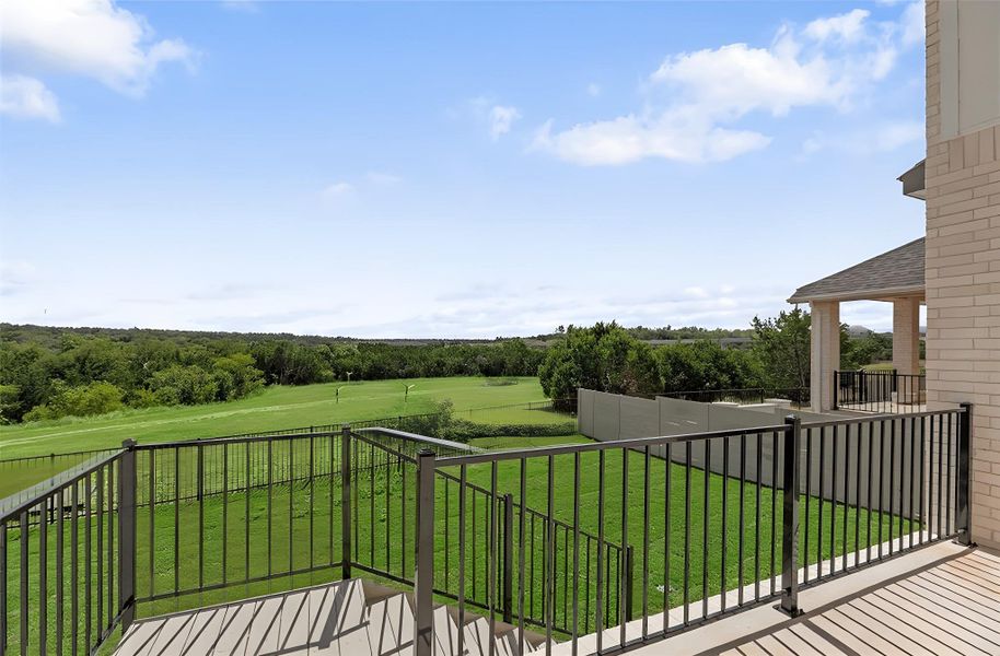 Balcony featuring view of wooded area