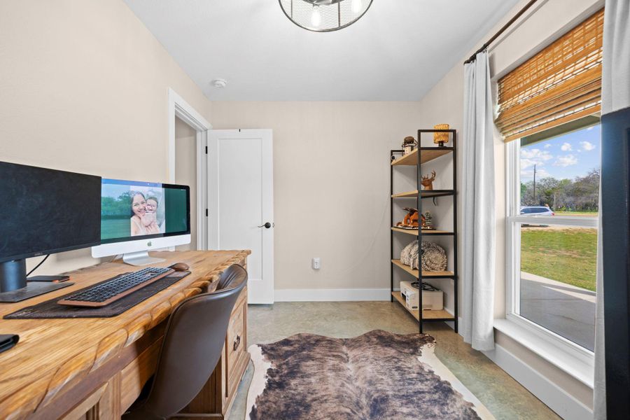 Home office featuring baseboards and concrete floors