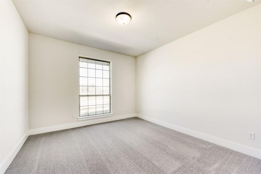 Spare room featuring light carpet and baseboards