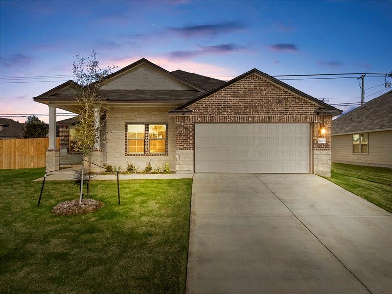 View of front of house with brick siding, concrete driveway, a garage, and covered porch