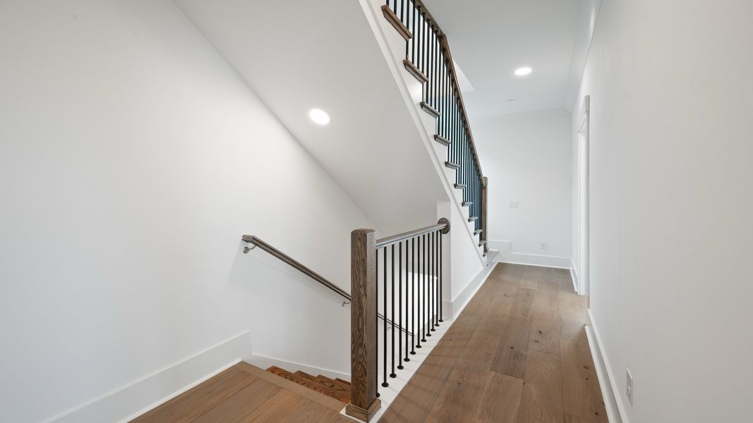 Second-floor hallway in the Sullivan home plan featuring hardwood flooring and access to the primary suite.
