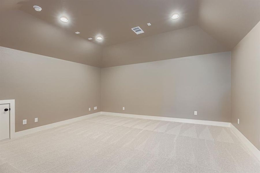 Unfurnished room with vaulted ceiling, light carpet, and recessed lighting