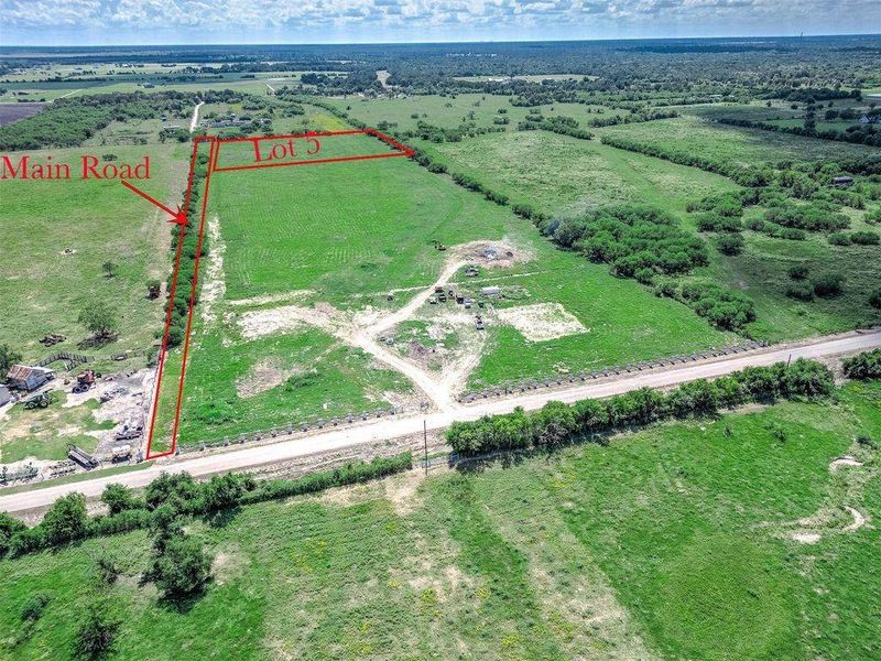 Aerial view of approximately 5 acres illustrating the lot layout, road frontage access, and open land with surrounding rural landscape.
