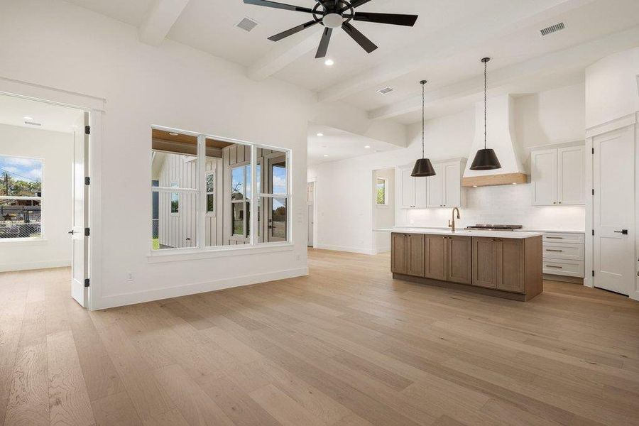 The property features an open-concept living space with hardwood floors, a ceiling fan, and large windows