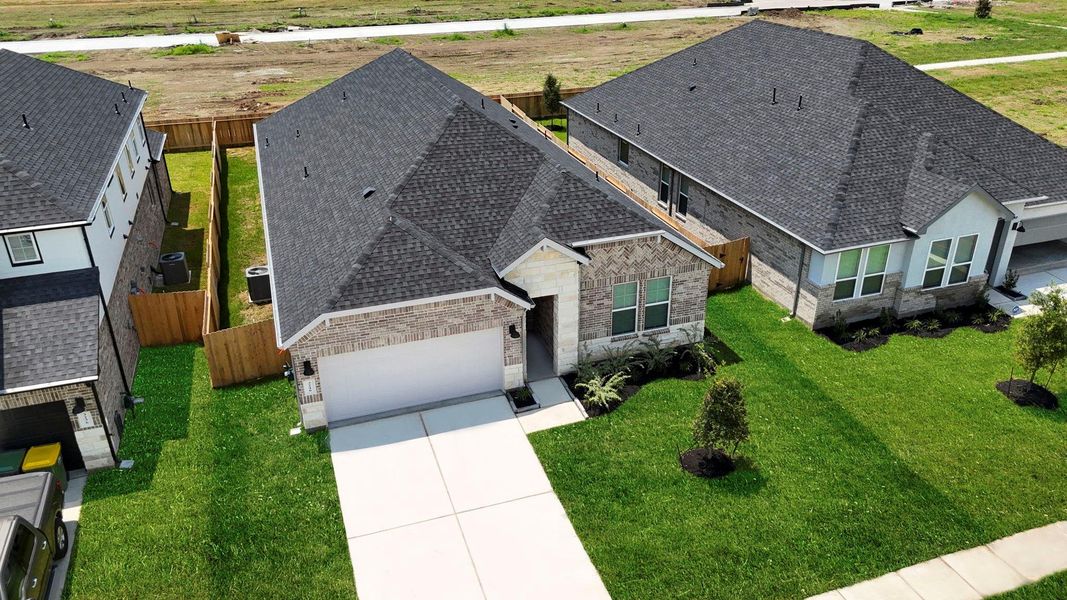 An aerial view of the newly built one story home with traditional architecture, a two car garage and a landscaped front yard An aerial view of the newly built one story home with traditional architecture, a two car garage and a landscaped front yard