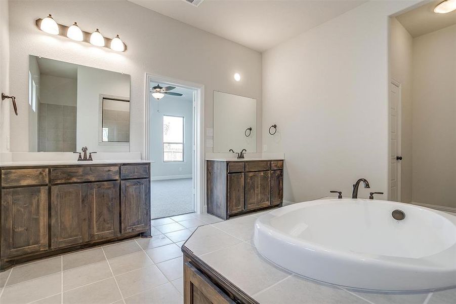 Bathroom with vanity, ceiling fan, a bath, and tile patterned floors