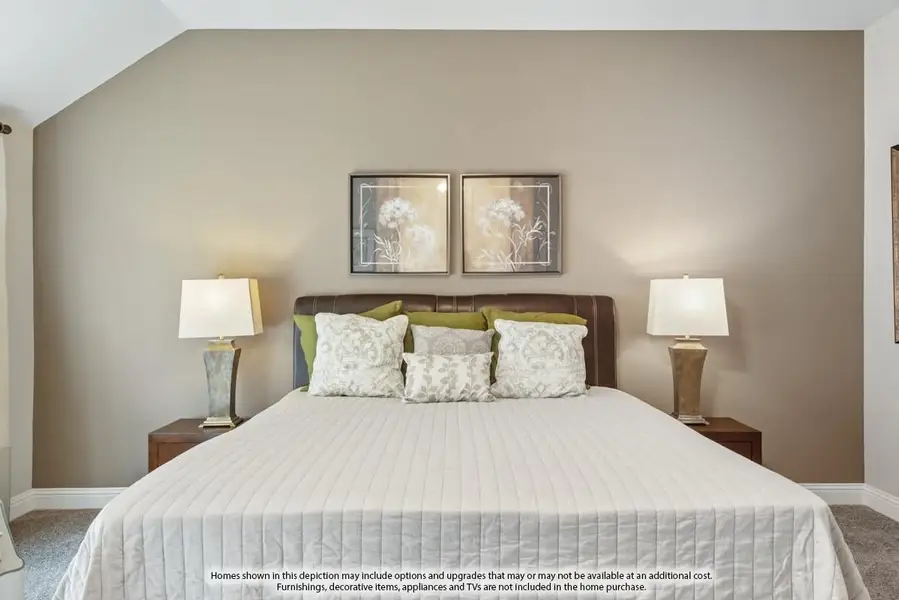 Bedroom with king bed, dark leather headboard, two nightstand lamps, and vaulted ceiling