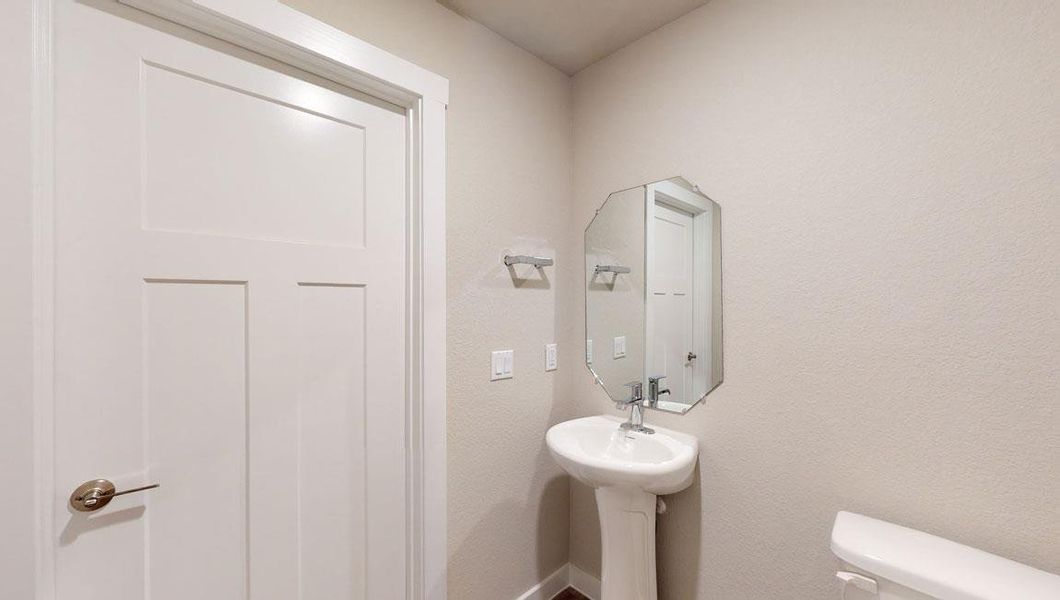 Half bathroom with toilet and baseboards