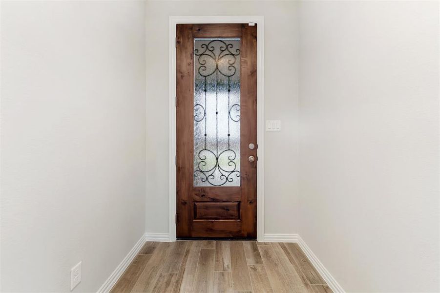 Doorway featuring wood finished floors and baseboards Doorway featuring wood finished floors and baseboards