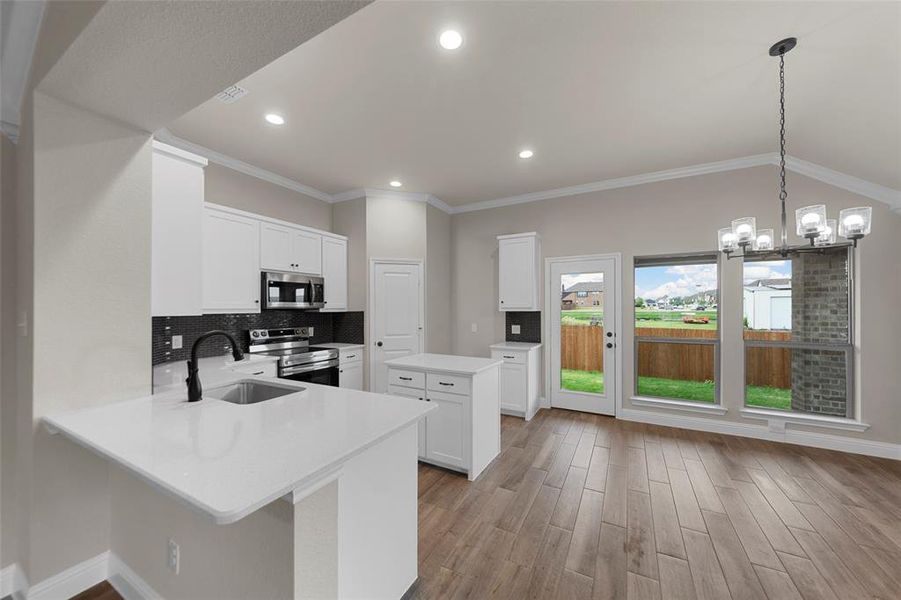 Modern kitchen and dining area featuring wood-finish flooring