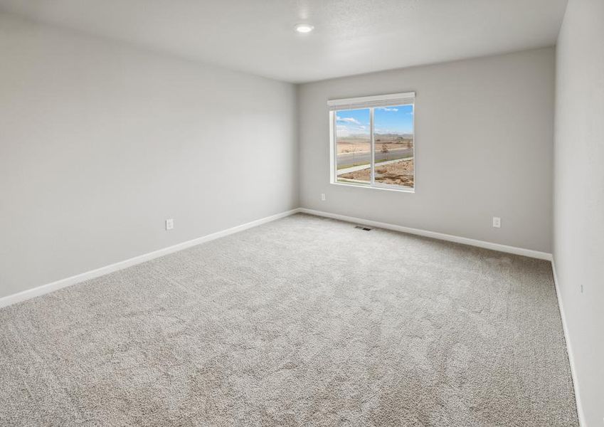 Expansive master bedroom with a window and an attached bathroom.