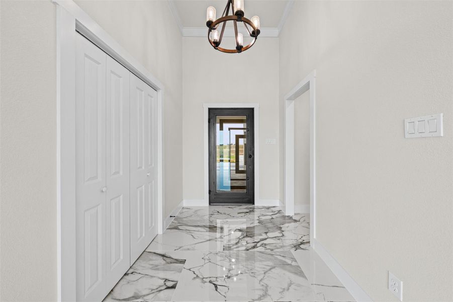Polished stone tile flooring runs throughout this welcoming entrance foyer with high ceilings.