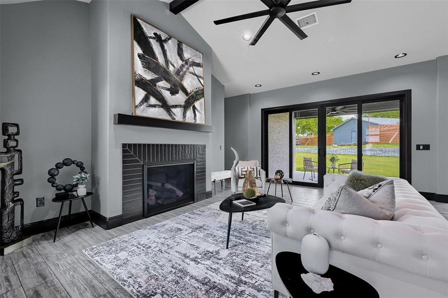 Living room featuring wood finished floors, ceiling fan, a fireplace, baseboards, and recessed lighting Living room featuring wood finished floors, ceiling fan, a fireplace, baseboards, and recessed lighting
