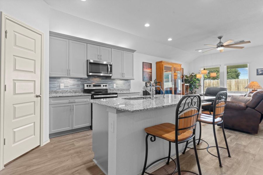 Another angle of the chef’s kitchen shows the expansive counter space, chic stylish tile backsplash, and open flow into the living area, creating the perfect setup for gatherings and everyday life. Wait till you see the large walk in the pantry! Another angle of the chef’s kitchen shows the expansive counter space, chic stylish tile backsplash, and open flow into the living area, creating the perfect setup for gatherings and everyday life. Wait till you see the large walk in the pantry!